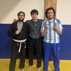 Groupe de praticiens en gis noir, blanc et bleu alignés sur le tatami du club