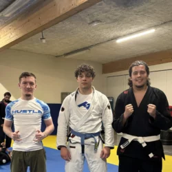 Groupe de praticiens en gis noir, blanc et bleu alignés sur le tatami du club