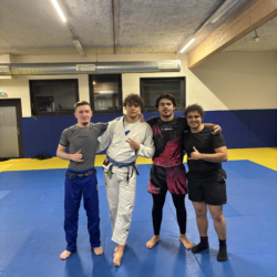 Groupe de praticiens en gis noir, blanc et bleu alignés sur le tatami du club